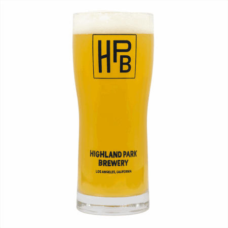 A tall glass of hazy, golden beer with a foamy head, served in the Classic Logo Glassware labeled "HPB" and "Highland Park Brewery, Los Angeles, California.