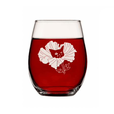 A set of two stemless clear wine glasses, each with a white floral illustration featuring a cat’s face at the center, filled with red liquid—Sad Cat Stemless Wine Glass (Set of 2).