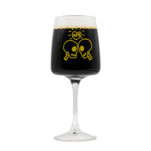 The Bottle Friends Brunch Glass 2026 features a yellow graphic of two cartoon skulls facing each other with "HPB" in a speech bubble, printed on the glass and pictured here filled with a dark liquid.