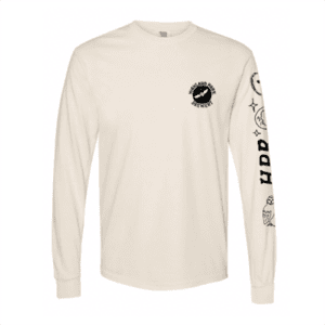 The Owl Long Sleeve is a cream-colored shirt featuring a small circular logo on the left chest and black graphics, including text and illustrations, along the right sleeve.