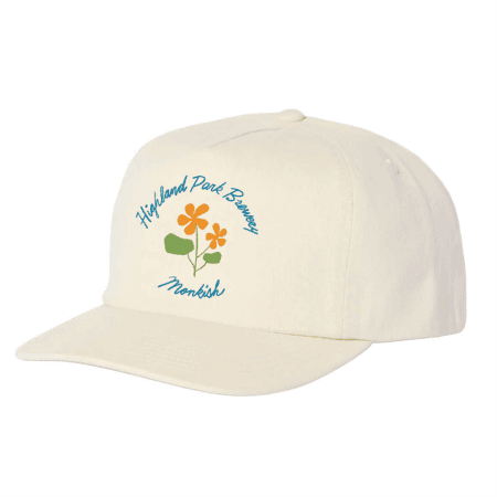 A cream-colored baseball cap featuring the text "Highland Park Brewery" and "Monkish" above and below an illustration of three orange flowers with green leaves.