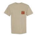 The Lone Pine x HPB Tee is a beige short-sleeve shirt featuring a small red and white name tag-style graphic with text on the left chest.