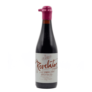 A dark glass bottle with a white label that reads “Revelator (2026)” in red script, sealed with red wax over the cap.